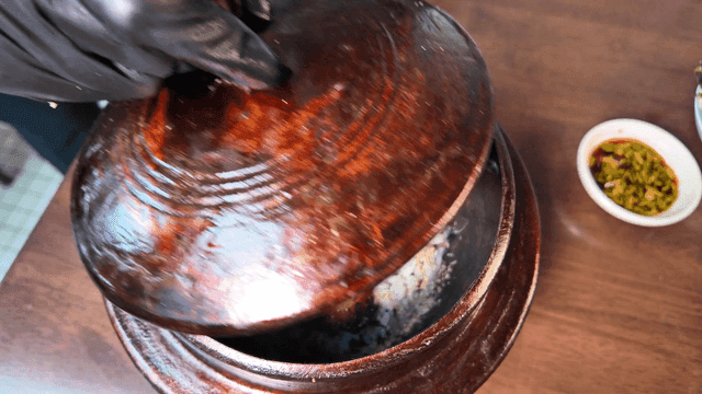 Opening a pot with grilled fish and rice