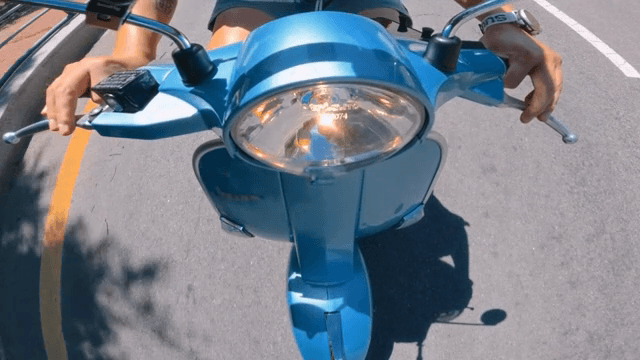 맑은 날 파란 스쿠터를 타는 사람