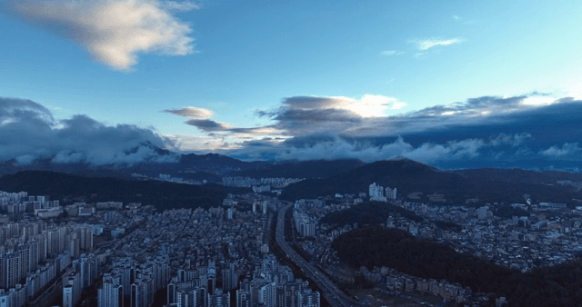 Cityscape with mountains and clouds