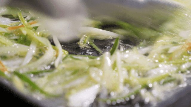 Green onion oil boiling over briquette fire