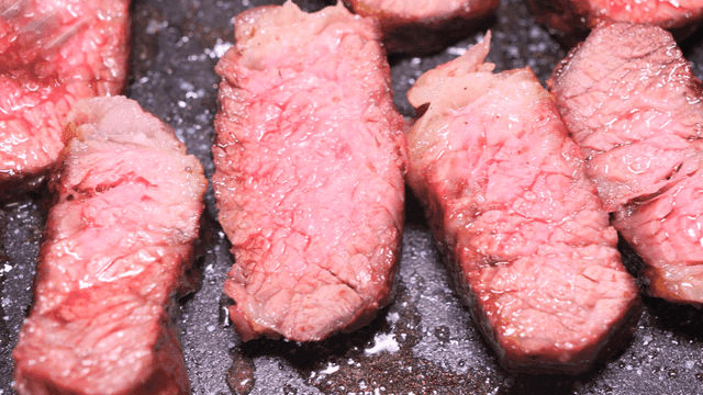 Juicy beef sizzling in pan