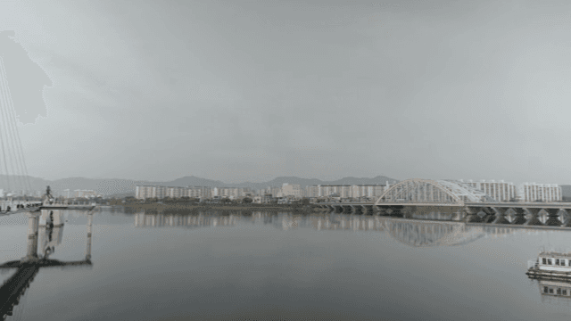 A bridge over a calm river with cityscape