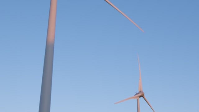 날개가 돌아가는 풍력발전기와 맑은 하늘