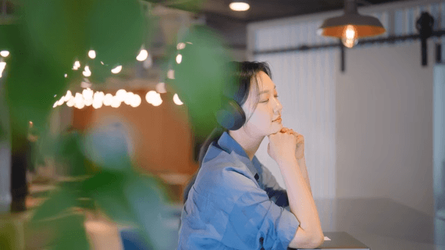 실내에서 헤드폰으로 음악을 즐기는 여성