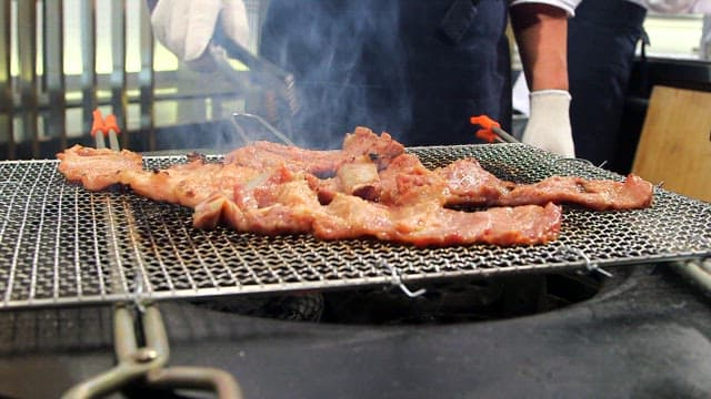 Grilling marinated pork ribs on a charcoal grill