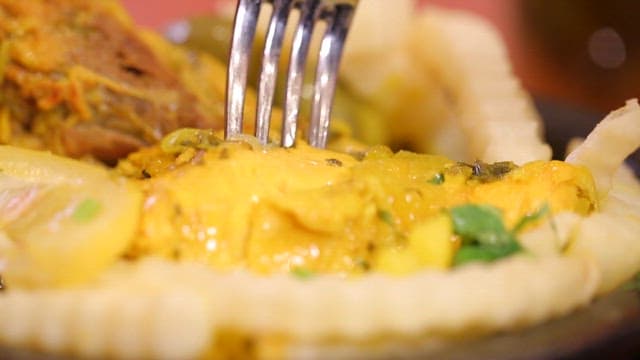 먹음직스러운 닭고기 요리를 포크로 집는 모습