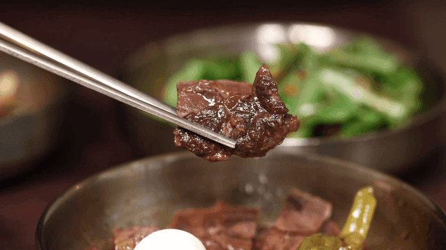 Rich beef braised in soy sauce lifted with chopsticks