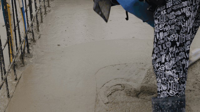 젖은 콘크리트 표면을 다듬는 작업자