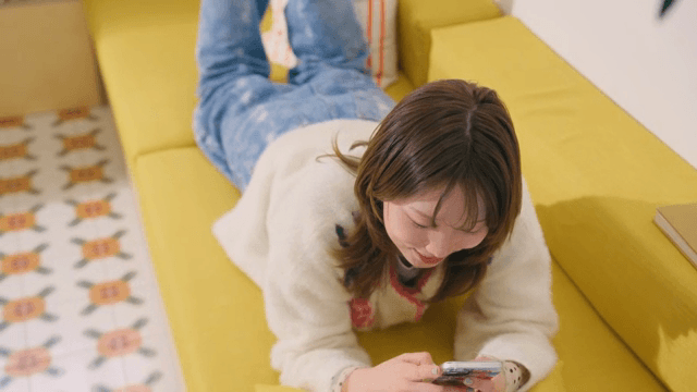 스마트폰을 사용하다가 바라보며 웃는 여성