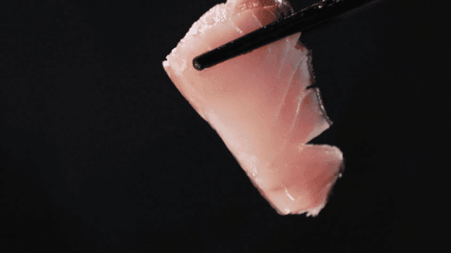 Fresh sashimi held with chopsticks