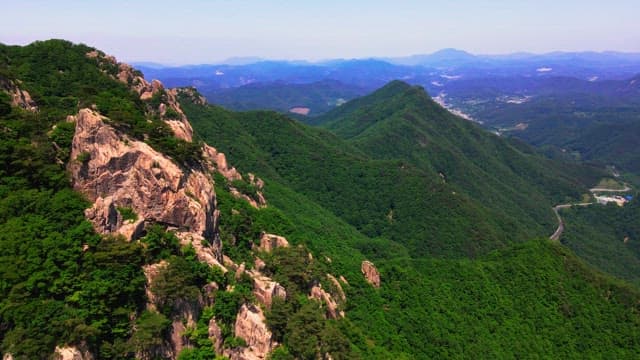 Lush green rocky mountains under clear skies