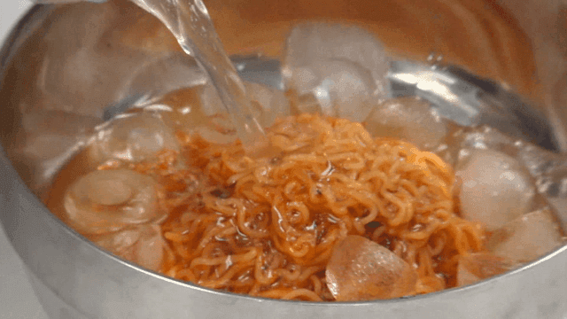 Cold naengmyeon broth poured over bibim ramen