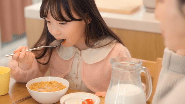 Child enjoying breakfast with cereal