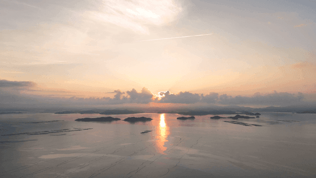 Sunrise over a calm sea with islands