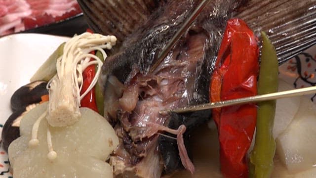 Cutting cooked fish with chopsticks