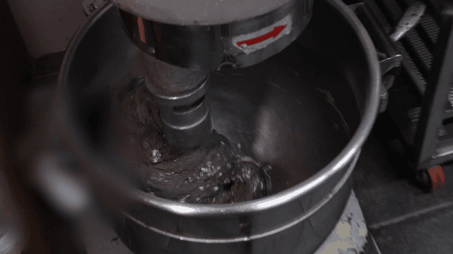 대형 반죽기에서 강하게 돌아가는 검은 반죽