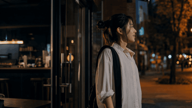 밤에 카페 밖에서 미소를 짓는 여성