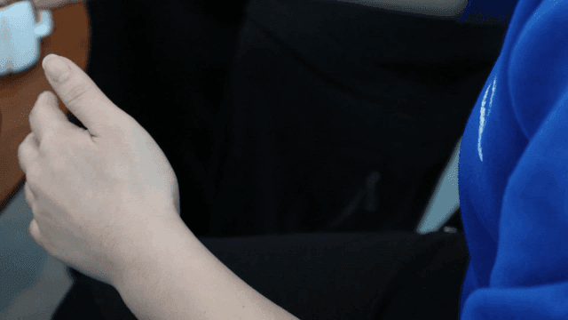 Hands clasped together in a blue sweater