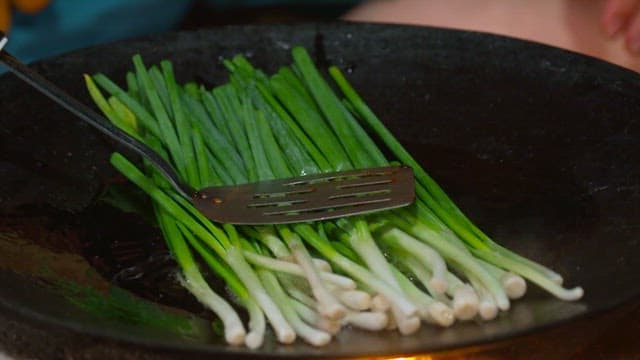 Green onions cooked in an oiled pan