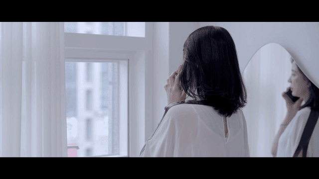 Woman talking on the phone by the window