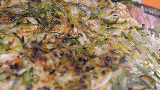 Sizzling charcoal-grilled green onion bulgogi in hot pan