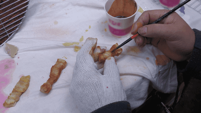 Craftsman meticulously hand-painting model of pork belly