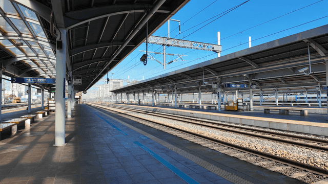 Empty train station platform under clear sky