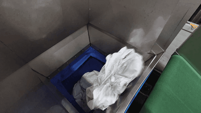 공장 기계의 컨베이어 벨트 위에 모이는 흰 천들