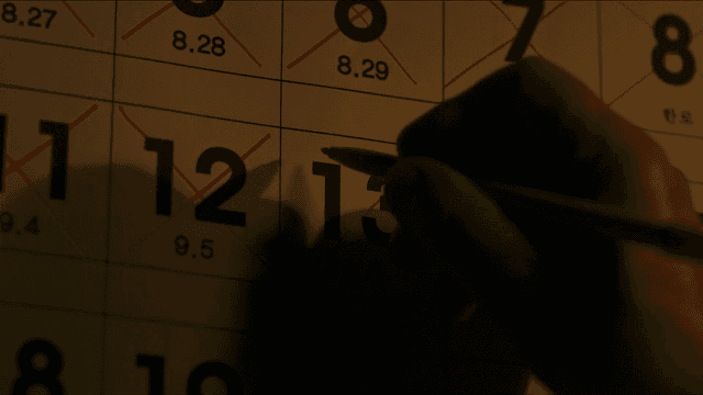 Hand marking date on calendar