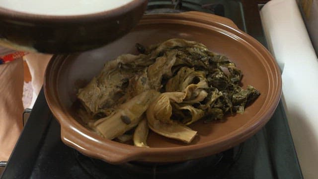 삭힌 김치가 담긴 냄비에 육수를 붓는 장면