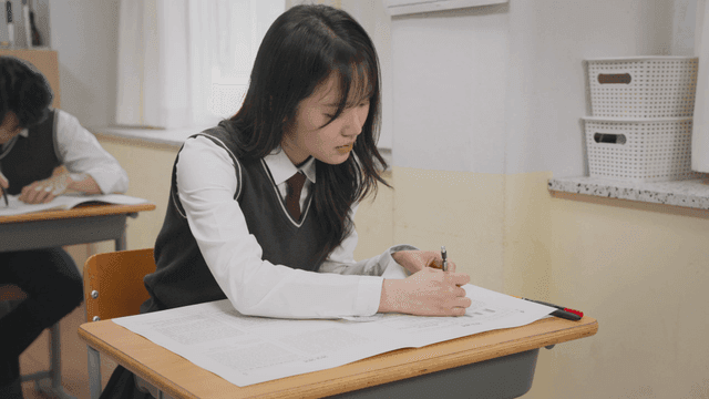시험 중 집중해서 문제를 푸는 학생