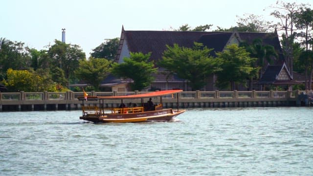 Boat ride along the river near a dock in a town on a sunny day