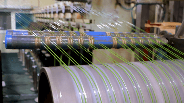 공장에서 녹색 실들을 뽑는 기계