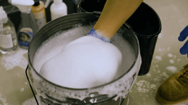 Cleaning Brush from a Bucket of Soapy Water