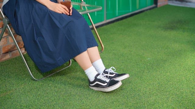 커피를 들고 휴식을 취하고 있는 젊은 여성의 다리