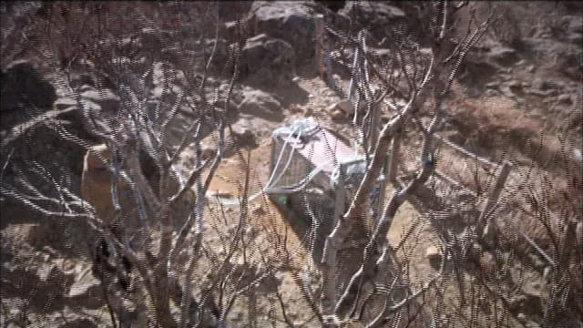 산에서 무언가를 싣고 가는 헬리콥터