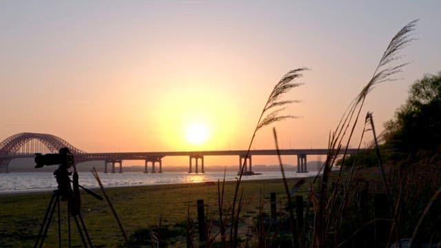 Sunset over a bridge with a camera setup