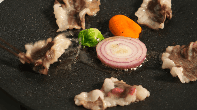 Vegetables and meat sizzling on a pan