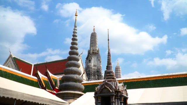 Ornate Thai temple spires under blue sky