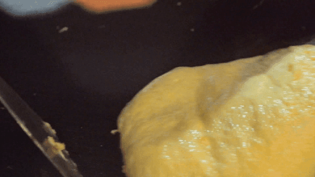 Omelette being cooked on a hot griddle