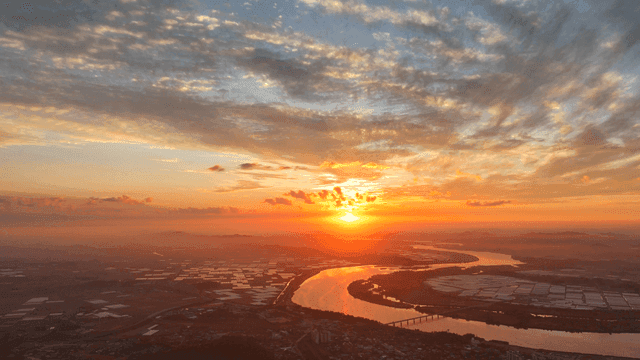 Sunset over a winding river and fields