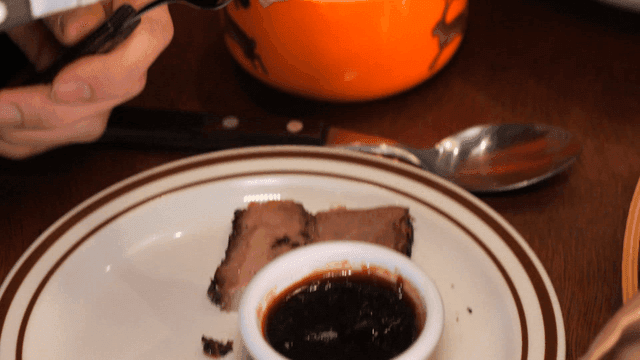 Meat eaten with barbecue sauce using fork and knife