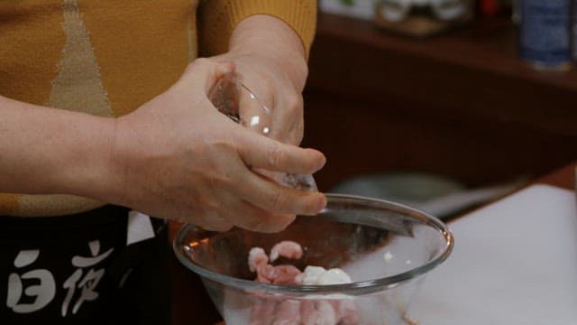 Mixing ingredients in a glass bowl inside a kitchen