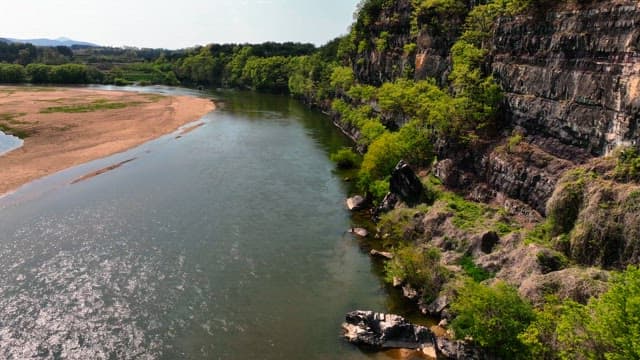 Tranquil river flowing beside rocky cliffs