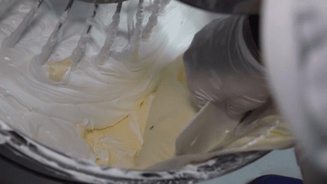 대형 반죽기에 버터를 추가하는 장면