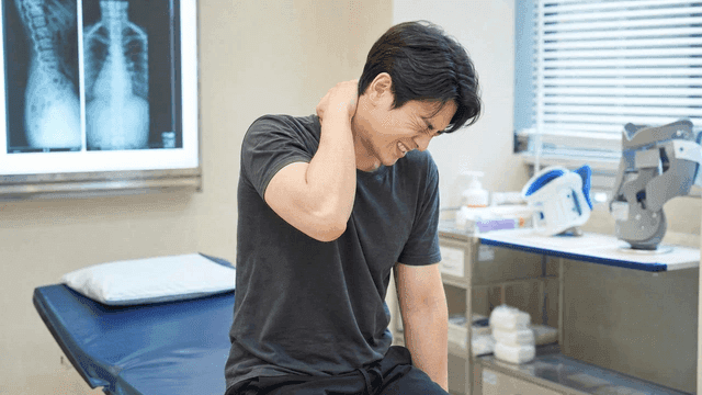 Man experiencing neck pain in doctor's office