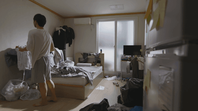 Man catching a bug in a messy room
