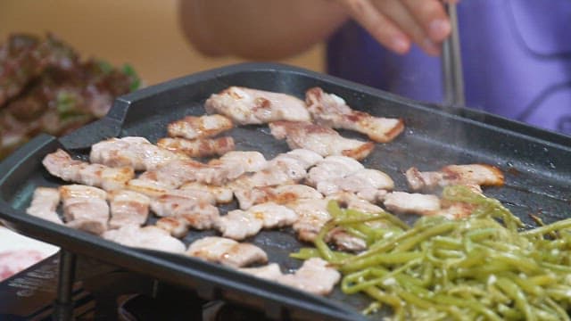 철판에서 지글거리며 구워지는 삼겹살과 고구마순