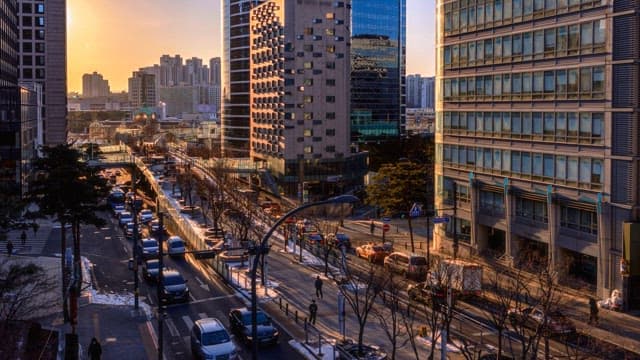 Busy city street during sunset transitioning into night