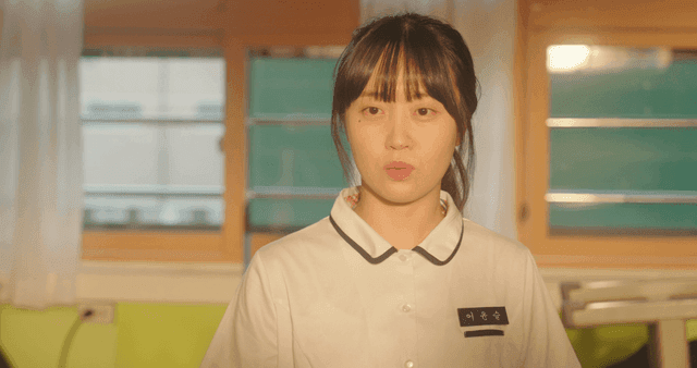 Schoolgirl holding a school uniform in a classroom